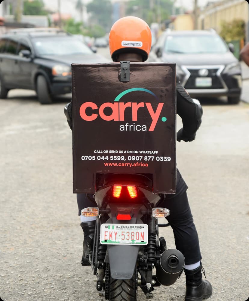 A man holding a delivery envelope in front of a house